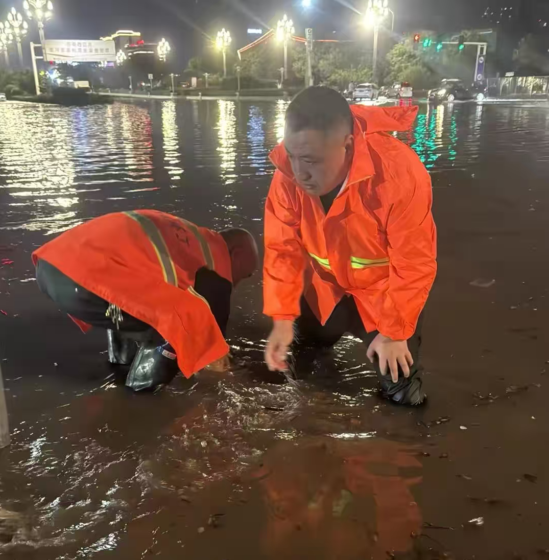 神州环境副总经理孔凡超带领环卫团队在雨中疏通下水道口.png