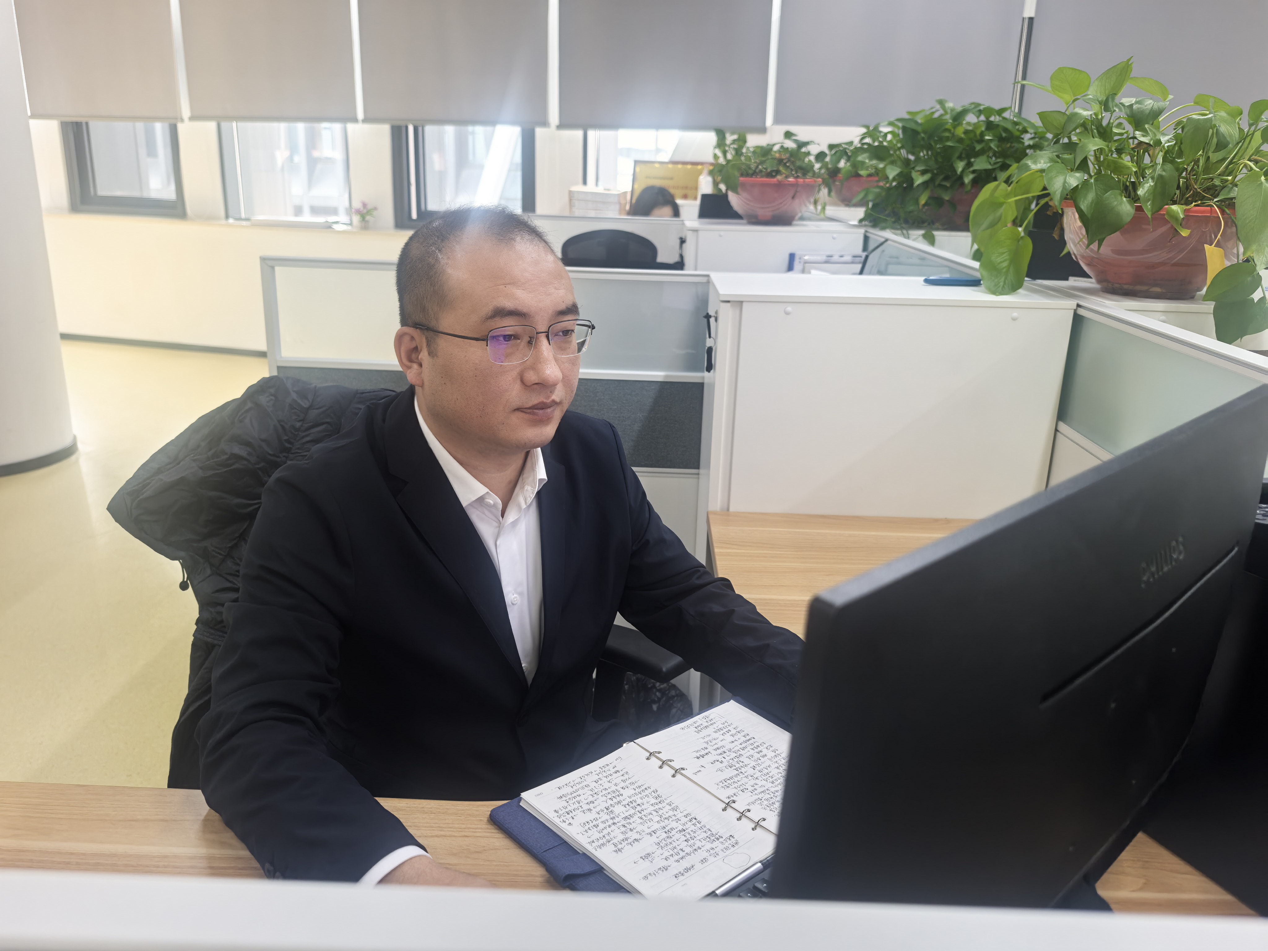 杨乾罡正在办公工位处理日常工作.jpg